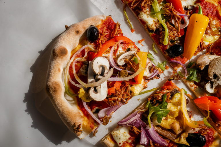 A freshly baked pesto pizza topped with vibrant basil leaves, mozzarella cheese, and cherry tomatoes on a rustic wooden board