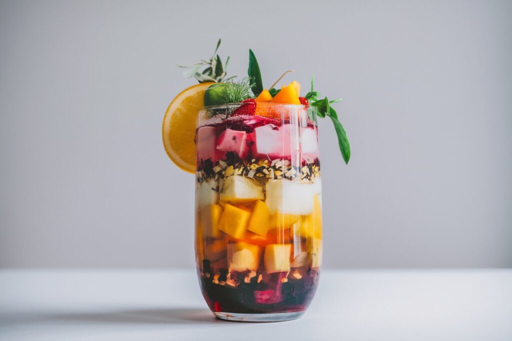 A vibrant and colorful image of a glass of loaded tea with layers of different ingredients clearly visible. The image could include a variety of fruits and herbs as garnish.