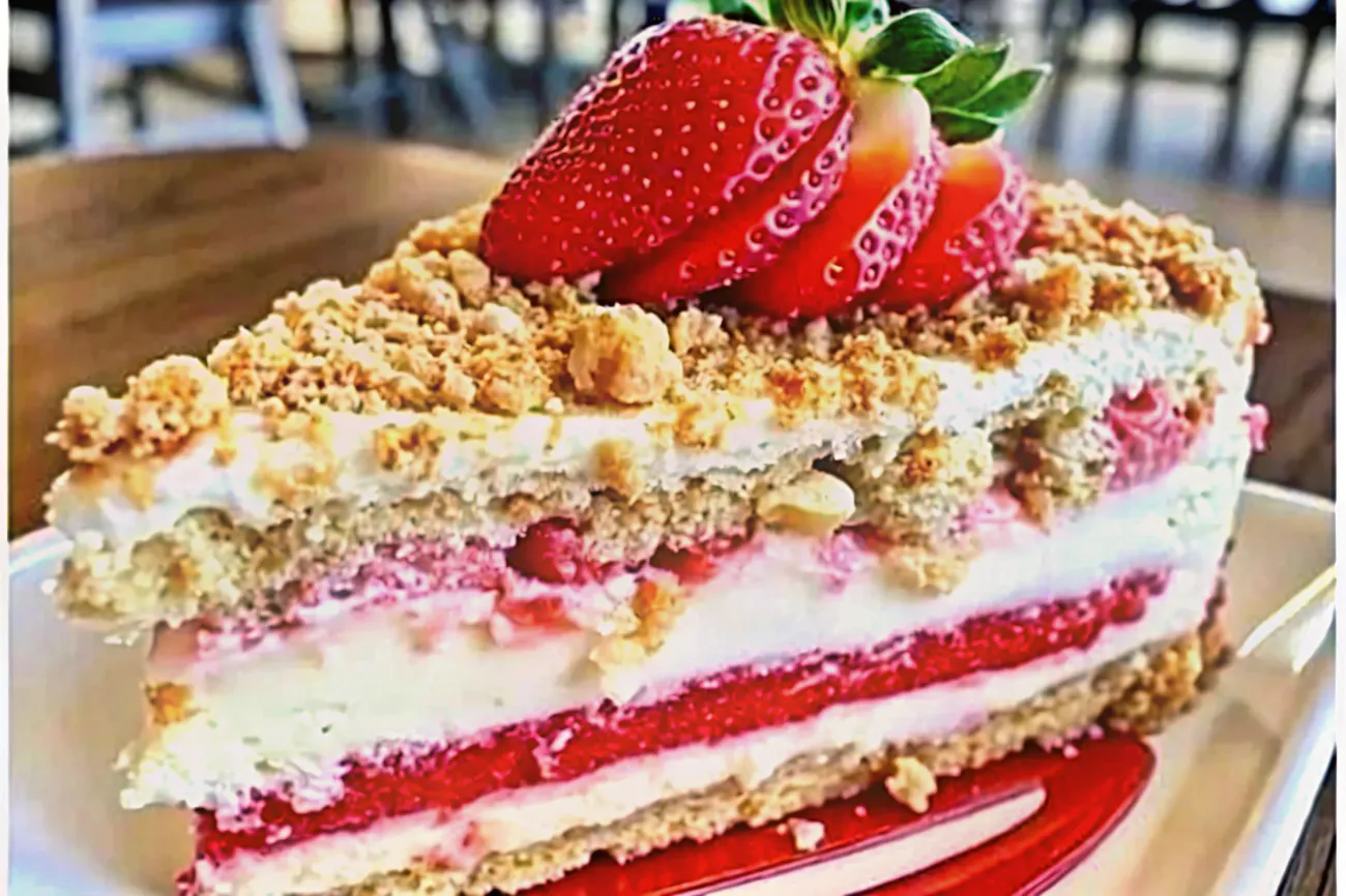 A delicious berrylicious strawberry crunch cheesecake featuring a golden crust, creamy filling, and fresh strawberries, presented elegantly on a wooden board.