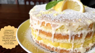 A delicious Limoncello Mascarpone Cake dusted with powdered sugar and garnished with lemon slices and mint leaves.