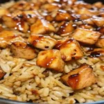 A delicious skillet of One-Pan Bold Honey BBQ Chicken Rice with golden chicken, flavorful rice, and a sticky-sweet glaze.