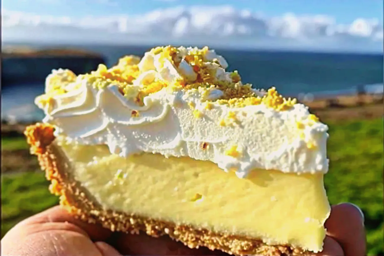 A delicious Lemon Bliss Tart with a creamy lemon filling, whipped cream topping, and crushed chocolate or lemon zest garnish