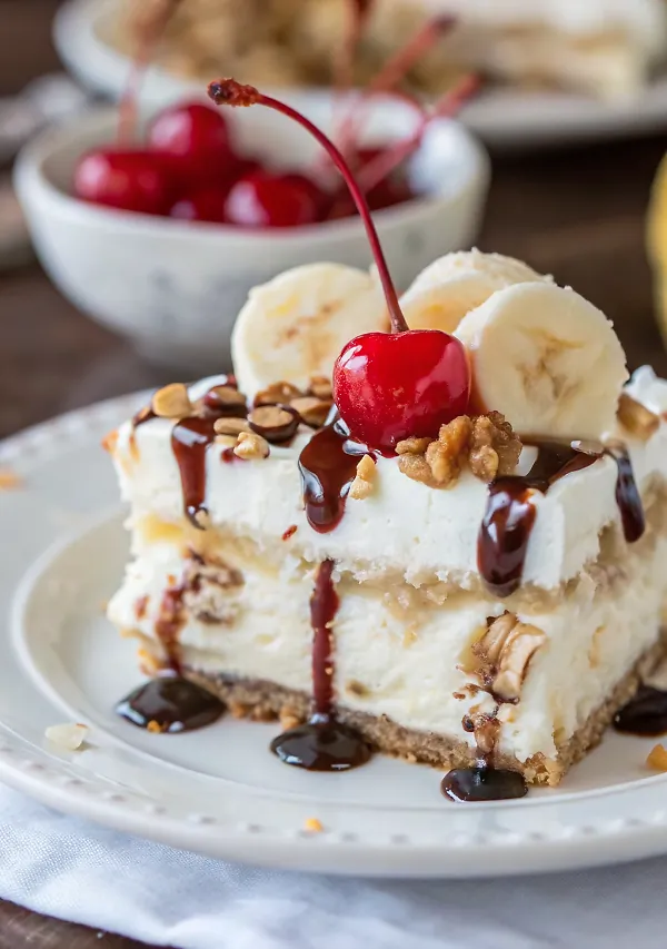 Beautifully plated slice of Southern-Style Banana Split Cake showing all colorful layers on white plate with garnish