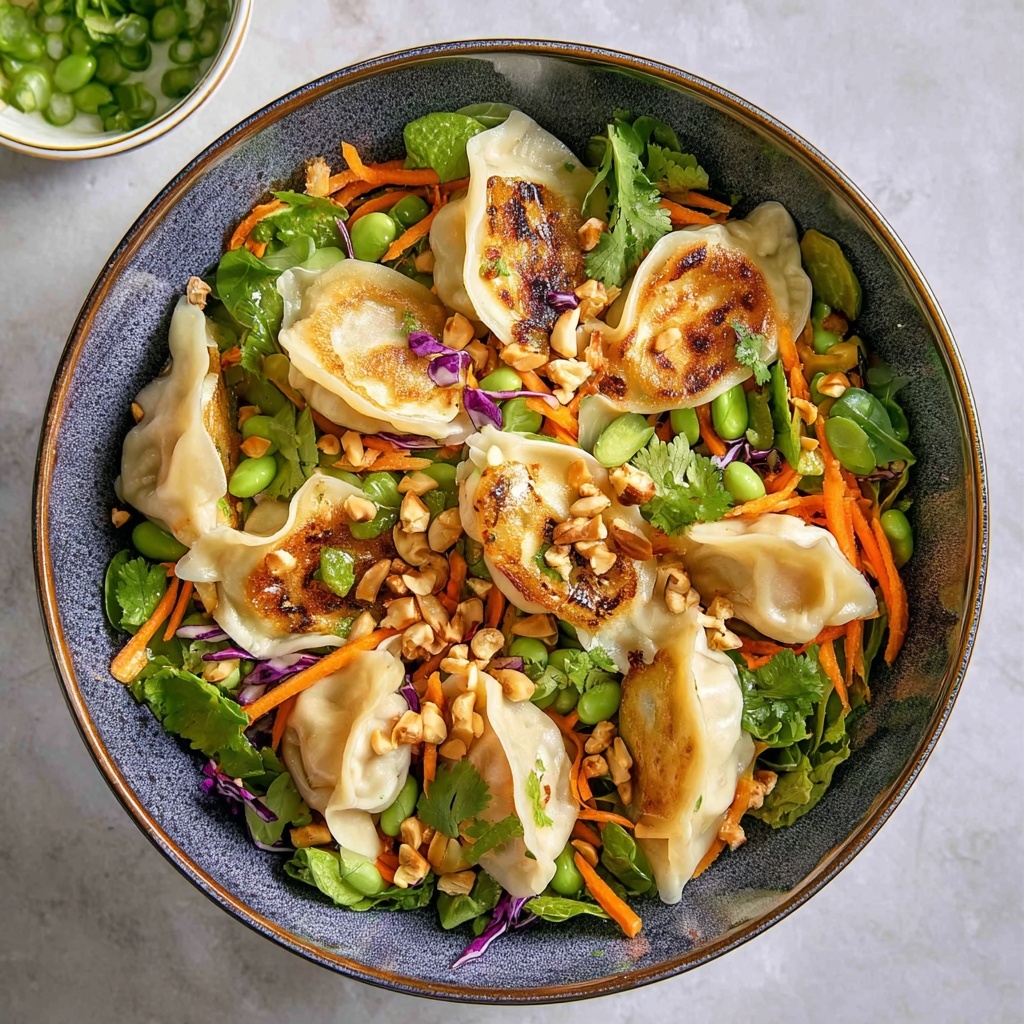 Beautiful finished dumpling salad in white bowl showing golden crispy dumplings arranged over colorful fresh vegetables with garnishes