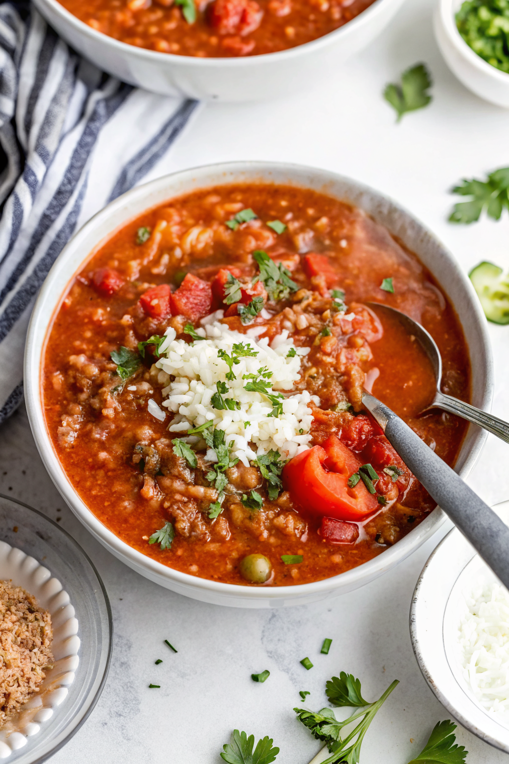 Beautifully plated Easy Stuffed Pepper Soup in a white ceramic bowl showcasing the vibrant red and green peppers against rich tomato broth