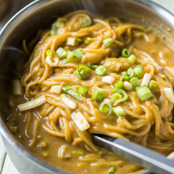 Beautiful bowl of finished One Pot Spicy Garlic Almond Butter Noodles garnished with green onions