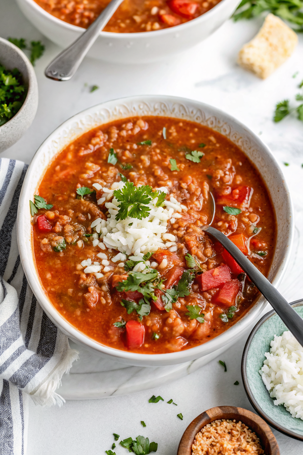 Finished Easy Stuffed Pepper Soup served in white bowl showing vibrant red and green peppers with perfectly cooked rice and garnished with fresh herbs