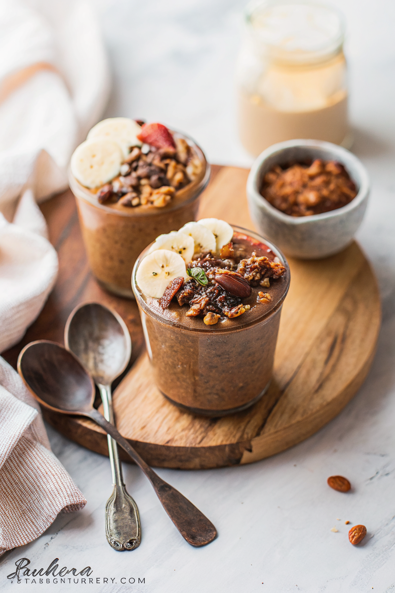 Beautiful finished chocolate peanut butter overnight oats in a glass jar topped with banana slices, granola, and a drizzle of peanut butter, ready to enjoy