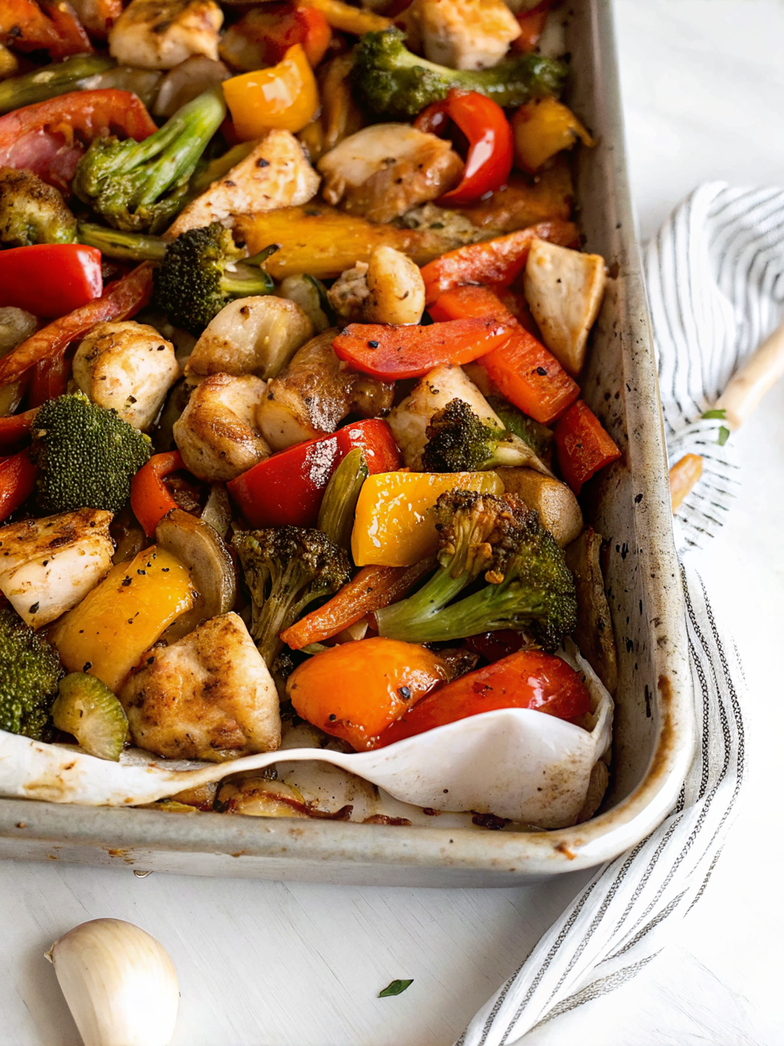 Finished One Pan Honey Garlic Chicken and Veggies on a sheet pan showing beautifully caramelized chicken pieces and colorful vegetables glistening with honey garlic glaze