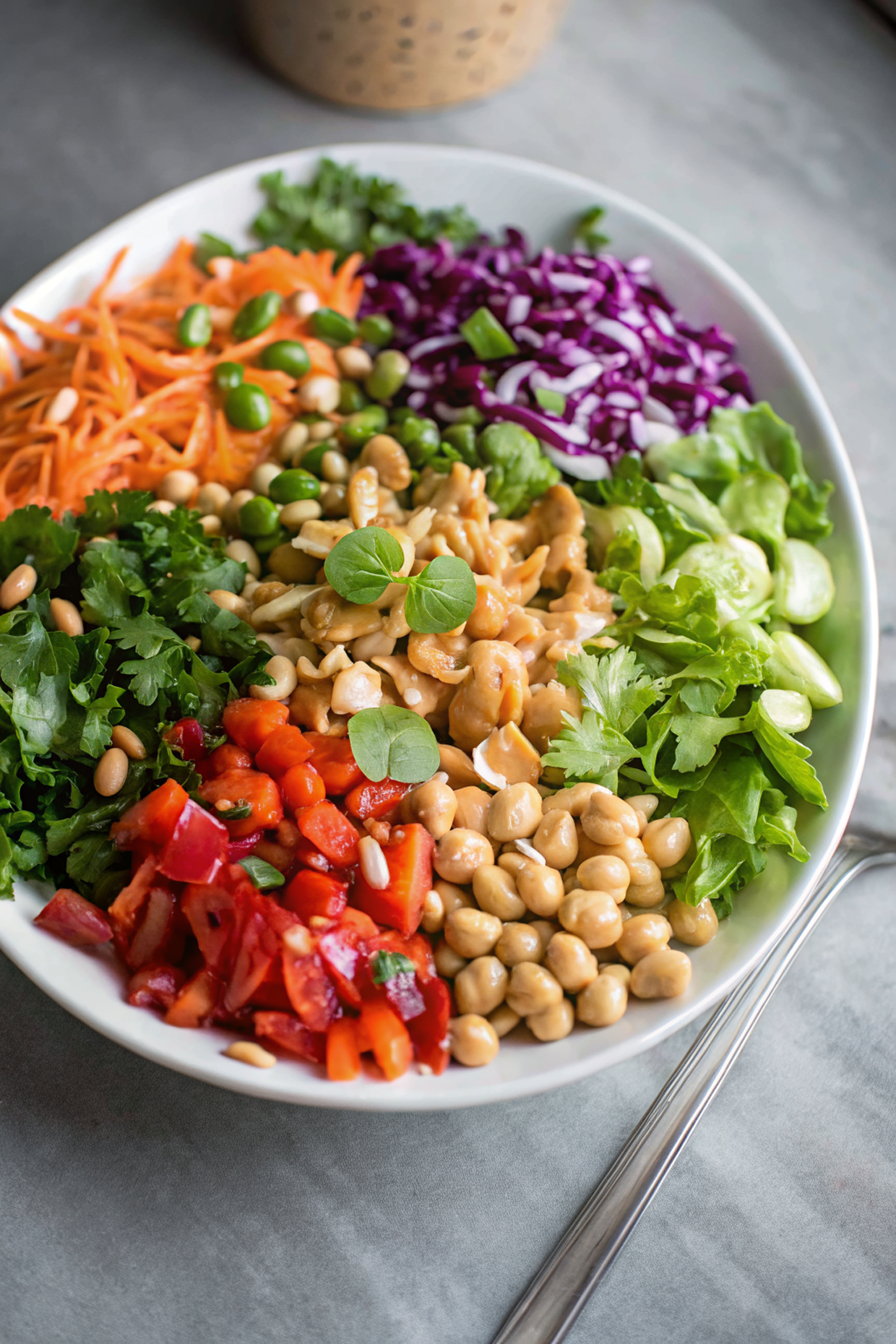 Final presentation of Thai Chickpea Salad with Peanut Dressing in a beautiful serving bowl, garnished with peanuts and fresh herbs