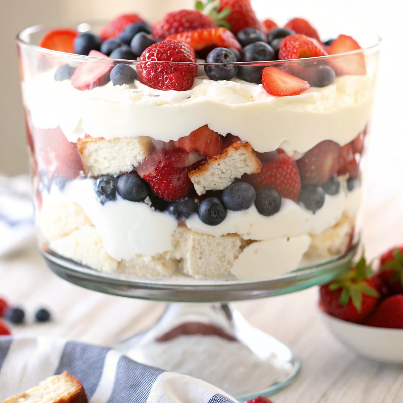 Finished no-bake berry trifle in a glass bowl showing beautiful layers of cream, berries, and cake